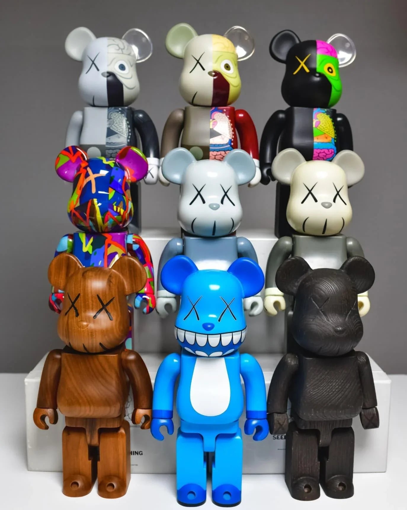 Collection of colorful and wooden Be@rbrick figures with pop art and anatomical designs on display